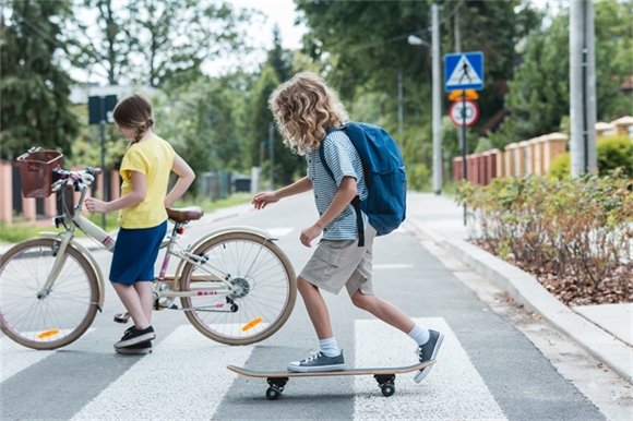 Photo of kids crossing sidewalk of street. 