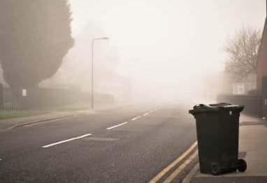 image of garbage can on side of curb